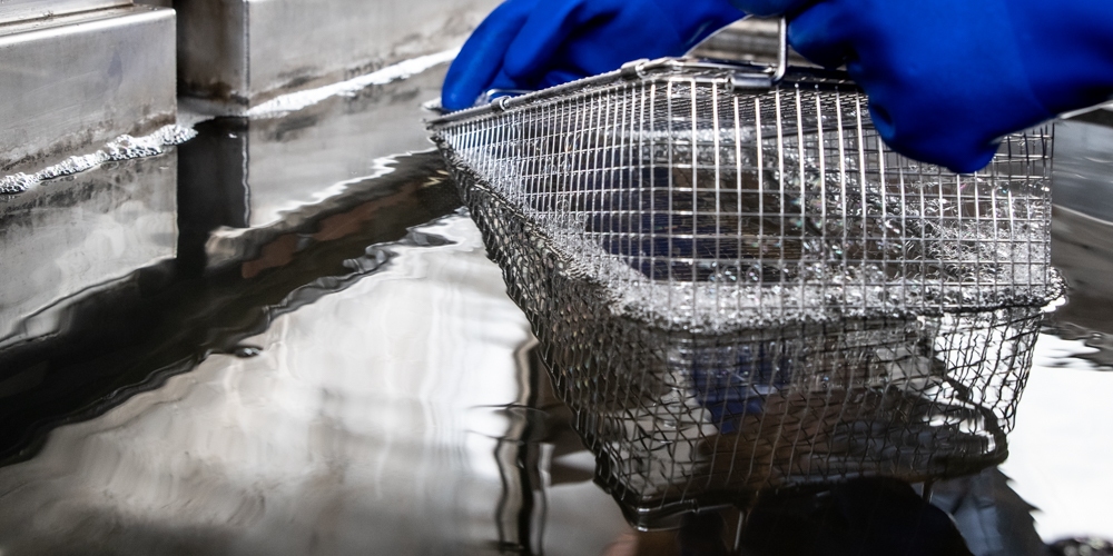 Basket being submerged in ultrasonic parts washer