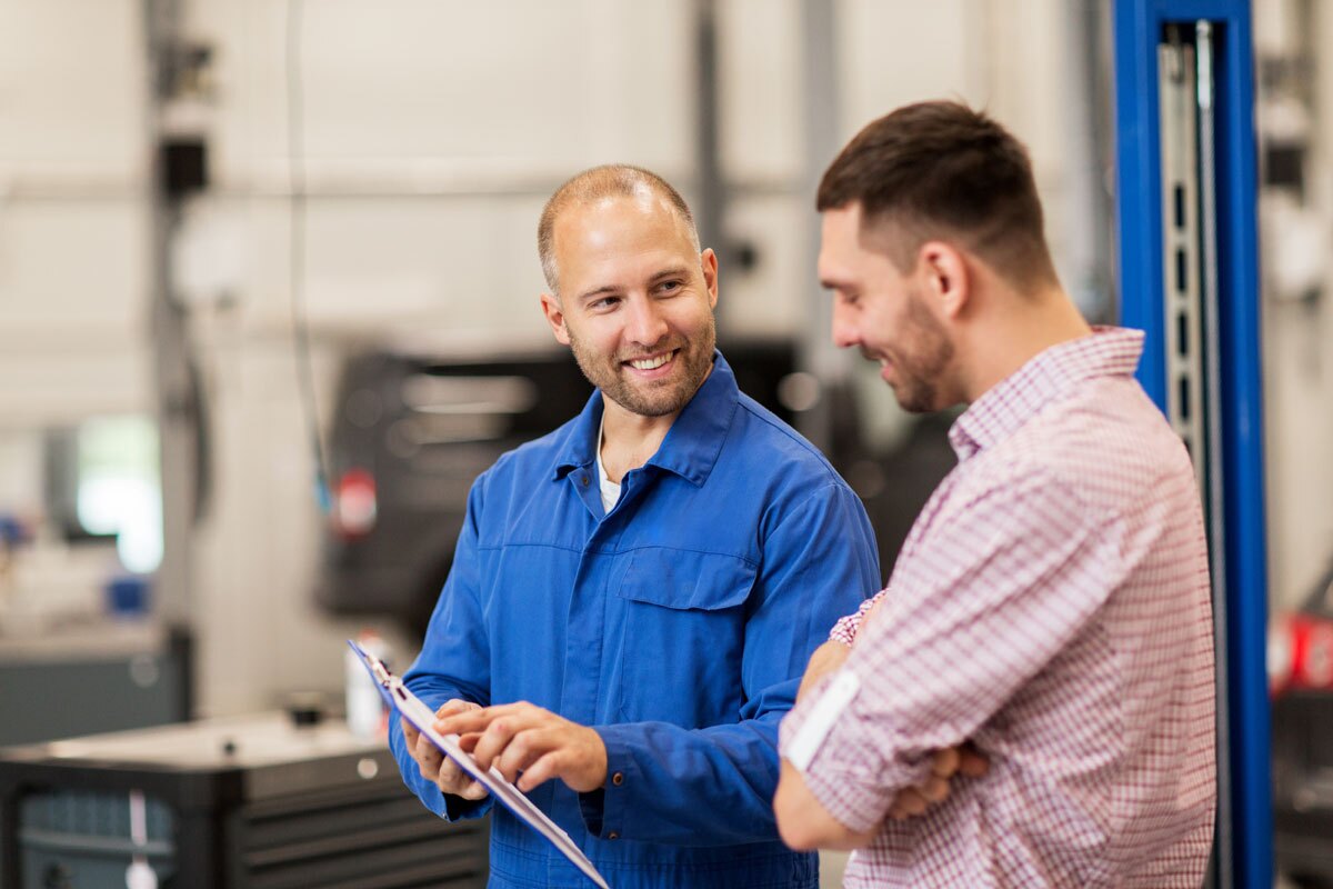 Workers on factory floor looking at clipboard