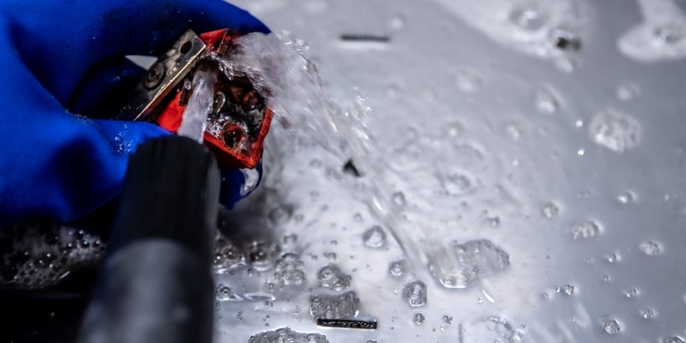 Spray washer cleaning oil from parts
