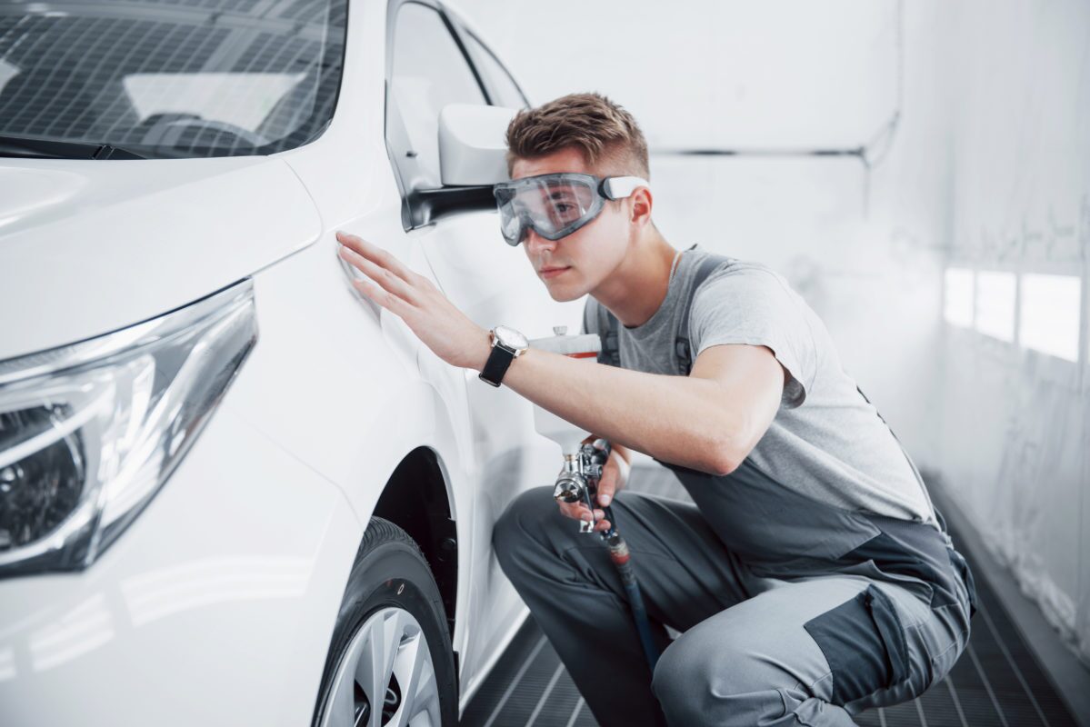Auto bodyshop mechanic using spray gun