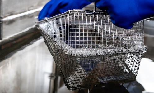 Basket being submerged in ultrasonic parts washer